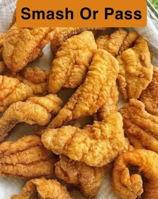 Delicious spicy fried catfish served with tartar sauce and lemon wedges.