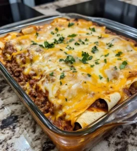 Delicious beef and cheese enchiladas served on a plate with toppings.
