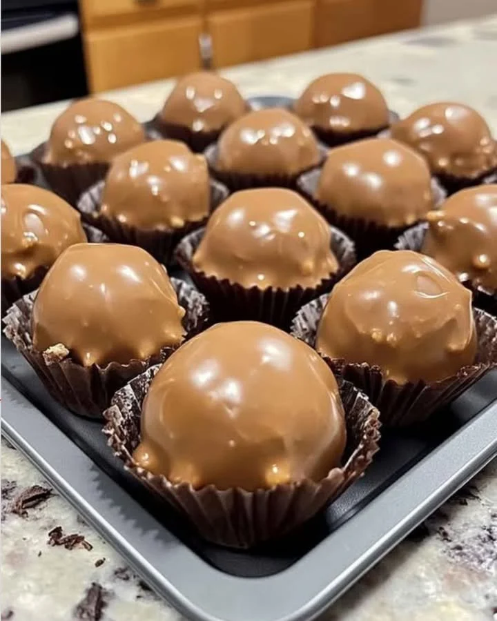 Homemade Butterfinger Balls coated in chocolate and sprinkled with crushed peanuts