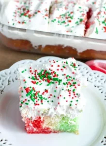 Delicious Christmas Poke Cake topped with festive decorations and whipped cream