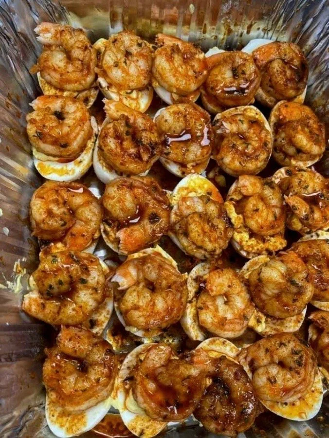 Deviled eggs topped with Cajun shrimp for a flavorful appetizer.