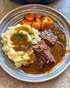 Delicious Instant Pot pot roast with mashed potatoes and gravy served on a plate.