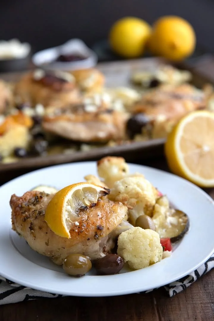 Healthy Keto Greek Lemon Chicken served with fresh herbs and lemon slices.
