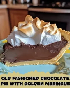 Slice of old fashioned chocolate pie topped with golden meringue