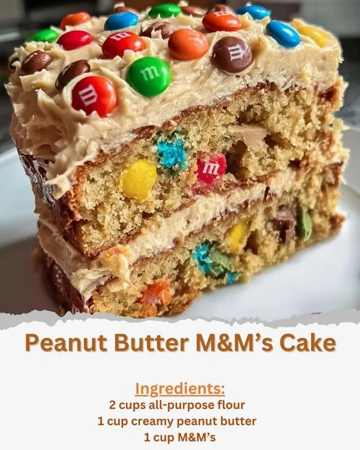 Delicious slice of Peanut Butter M&M’s Cake topped with colorful M&M's and peanut butter icing.