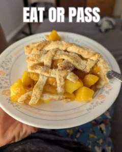 Slice of perfect peach pie on a rustic wooden table