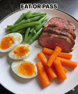 Prime rib steak served with soft-boiled eggs, green beans, and carrots
