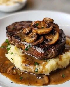 Delicious steak with mushroom gravy and creamy mashed potatoes on a plate
