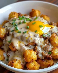 Tater Tot Breakfast Bowl with Sausage Gravy and toppings, perfect for breakfast.