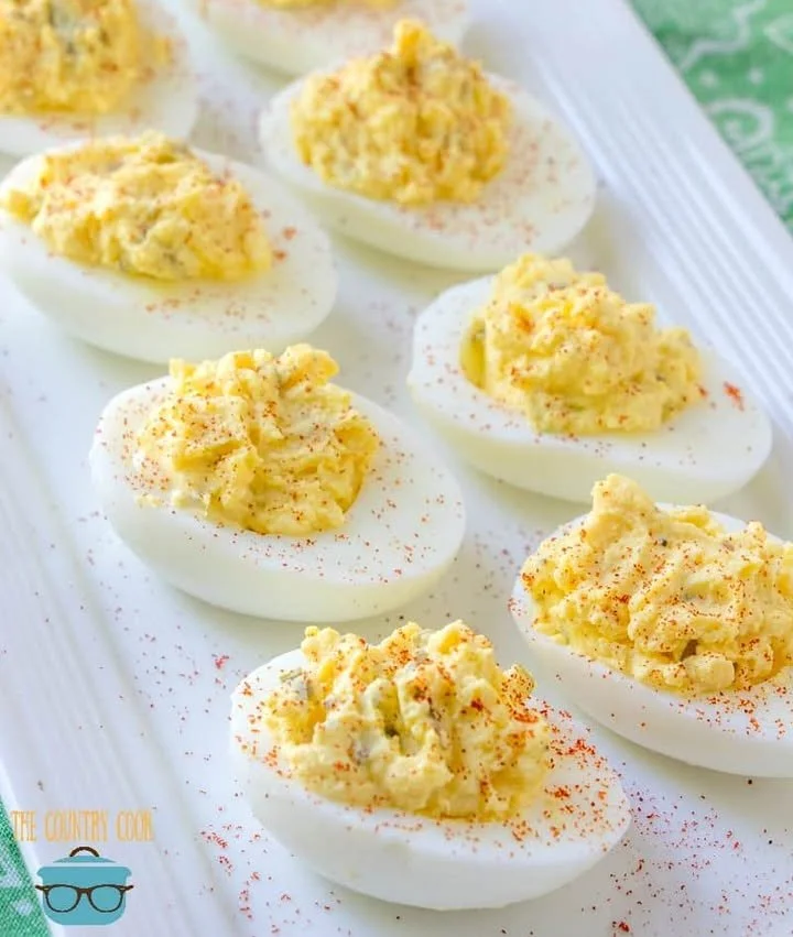Plate of the best ever deviled eggs garnished with paprika and herbs