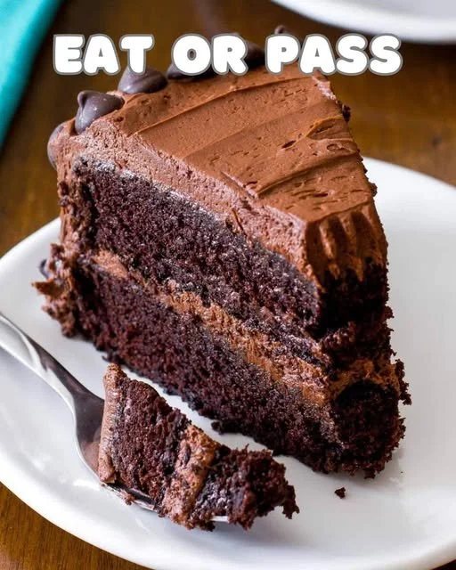 Decadent triple chocolate cake topped with chocolate shavings and frosting.
