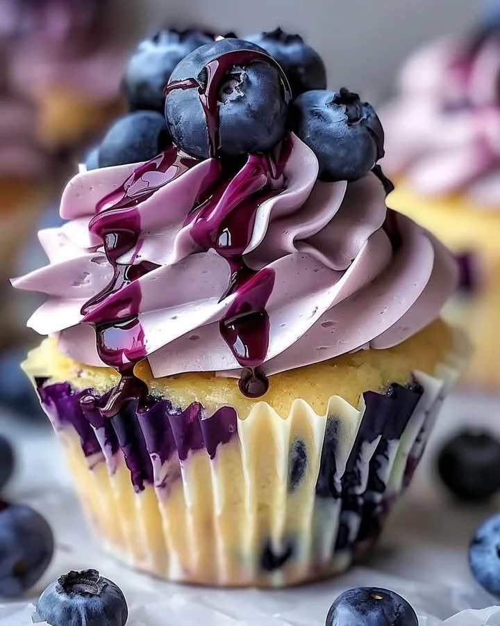 White chocolate blueberry cheesecake cupcakes with creamy topping and fresh blueberries
