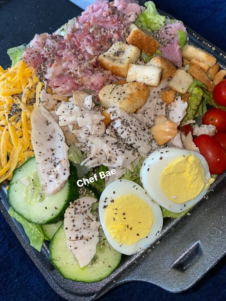 A variety of healthy snacks including fruits, nuts, and snacks on a wooden table.