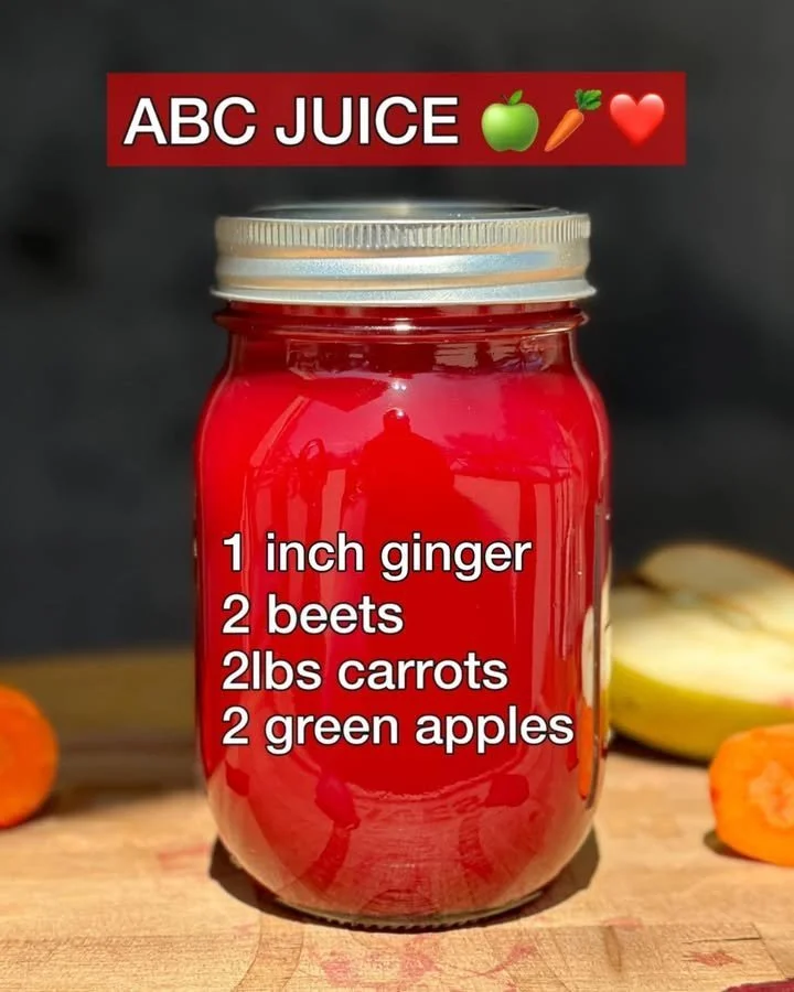 A glass of fresh ABC Juice surrounded by vibrant fruits and vegetables.