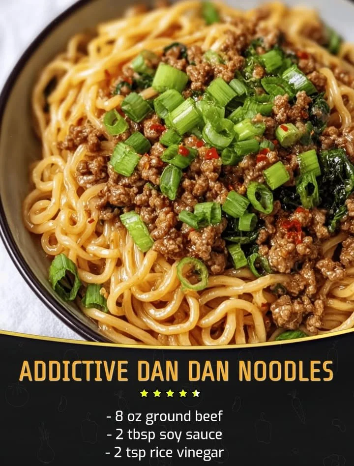 Bowl of addictive Dan Dan Noodles garnished with chopped peanuts and green onions