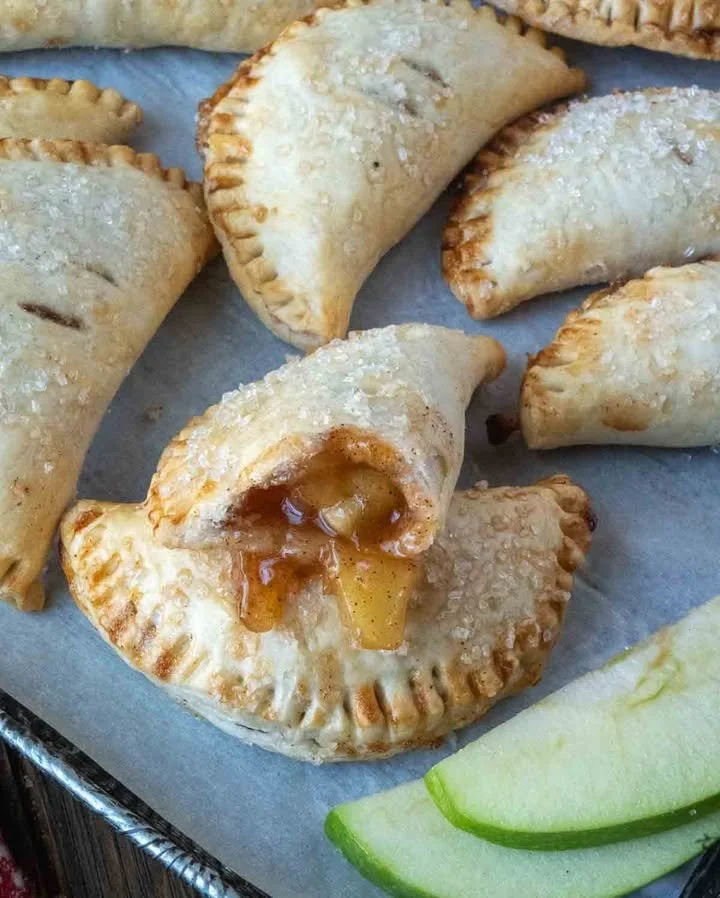 Freshly baked air fryer apple hand pies on a white plate