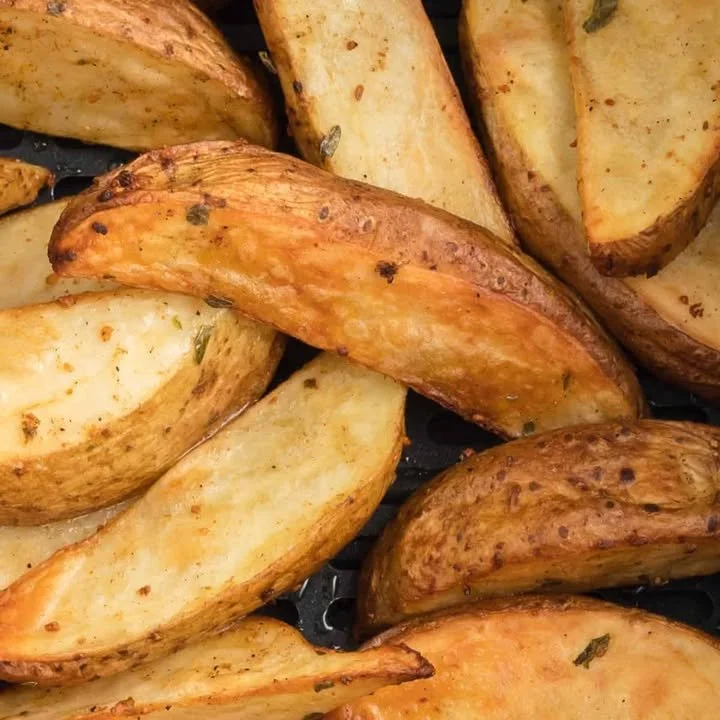 Crispy air fryer potato wedges served in a bowl.