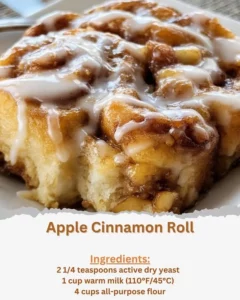 Freshly baked apple cinnamon roll with icing on top served on a plate