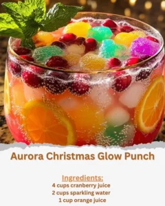 Aurora Christmas Glow Punch in a festive glass with colorful fruits