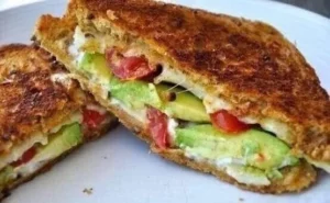 Avocado, mozzarella, and tomato grilled cheese sandwich on a plate