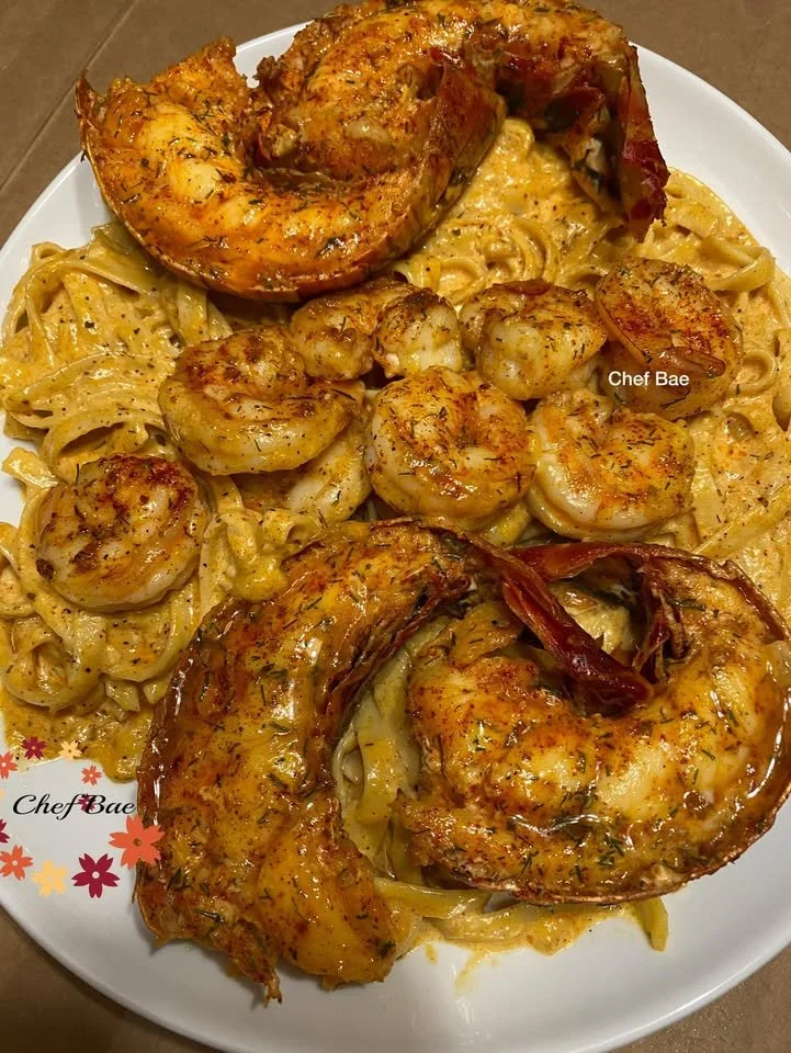 Plate of Bae’s Cajun Shrimp and Lobster Pasta garnished with herbs.