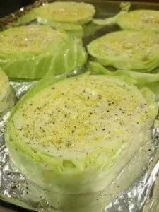 Delicious baked cabbage steaks served on a plate with herbs and spices.