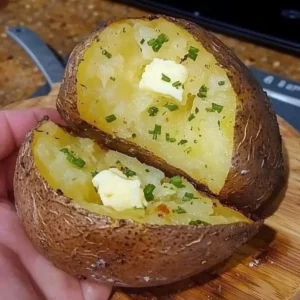 Delicious baked potato topped with butter, sour cream, and chives