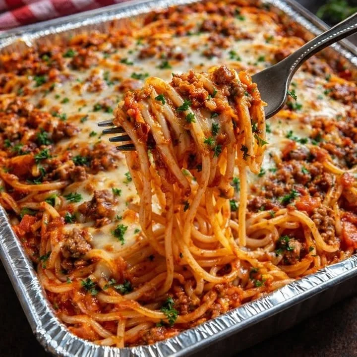 Delicious baked spaghetti topped with savory meat sauce and melted cheese