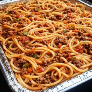 Baked spaghetti with meat sauce in a casserole dish, topped with melted cheese.