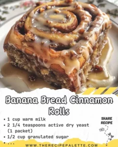 Fluffy banana bread cinnamon rolls topped with cream cheese icing on a plate.