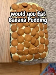 Delicious banana pudding dessert in a glass topped with whipped cream and banana slices.