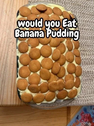 Delicious banana pudding dessert in a glass topped with whipped cream and banana slices.