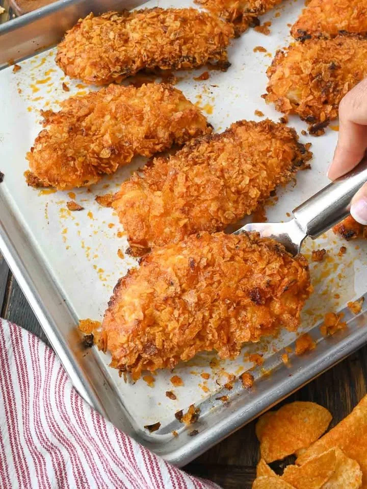 BBQ Potato Chip Chicken Tenders plated with a side of dipping sauce