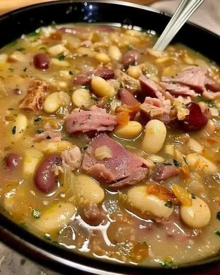 Delicious Bean and Ham Hock Soup in a rustic bowl garnished with herbs
