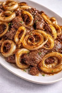 Plate of beef liver and onions served with herbs and spices