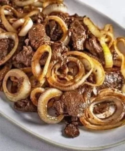 Plate of beef liver and onions served with fresh herbs