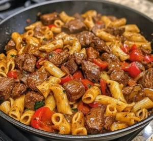 Delicious plate of beef steak pasta garnished with herbs and spices
