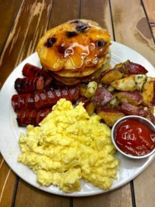 Stack of fluffy blueberry pancakes with fresh blueberries and syrup