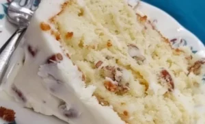 Delicious Italian Cream Cake made from cake mix topped with cream and nuts