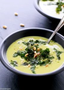 Bowl of creamy cauliflower kale soup garnished with herbs