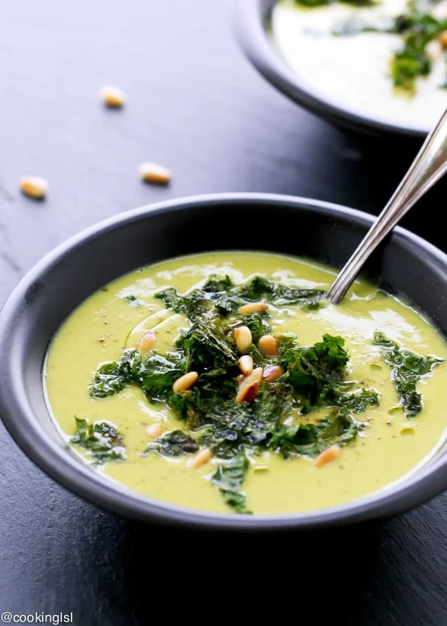 Bowl of creamy cauliflower kale soup garnished with herbs