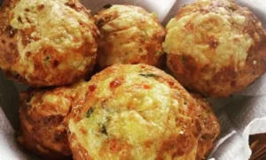 Freshly baked cheddar cheese muffins on a cooling rack