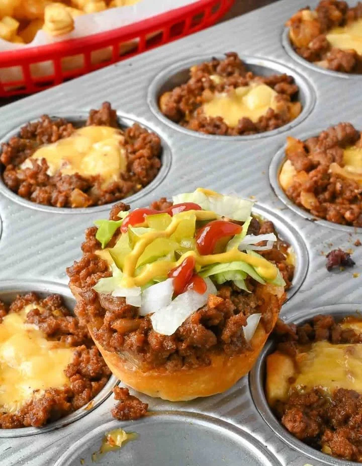 Cheeseburger cups served on a plate with fresh toppings and melted cheese