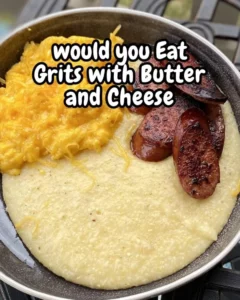 Bowl of creamy cheesy grits topped with cheese and herbs