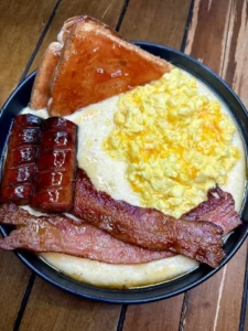 Cheesy grits bowl topped with cheesy scrambled eggs served in a bowl
