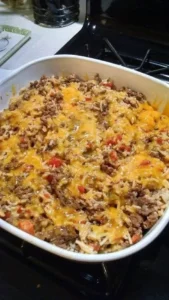 Cheesy Ground Beef and Rice Bake topped with melted cheese and herbs