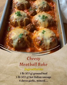 Cheesy meatball bake topped with melted cheese and herbs in a baking dish