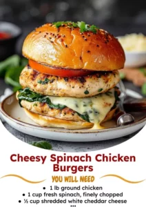 Cheesy spinach chicken burgers stacked on a plate, garnished with fresh herbs.