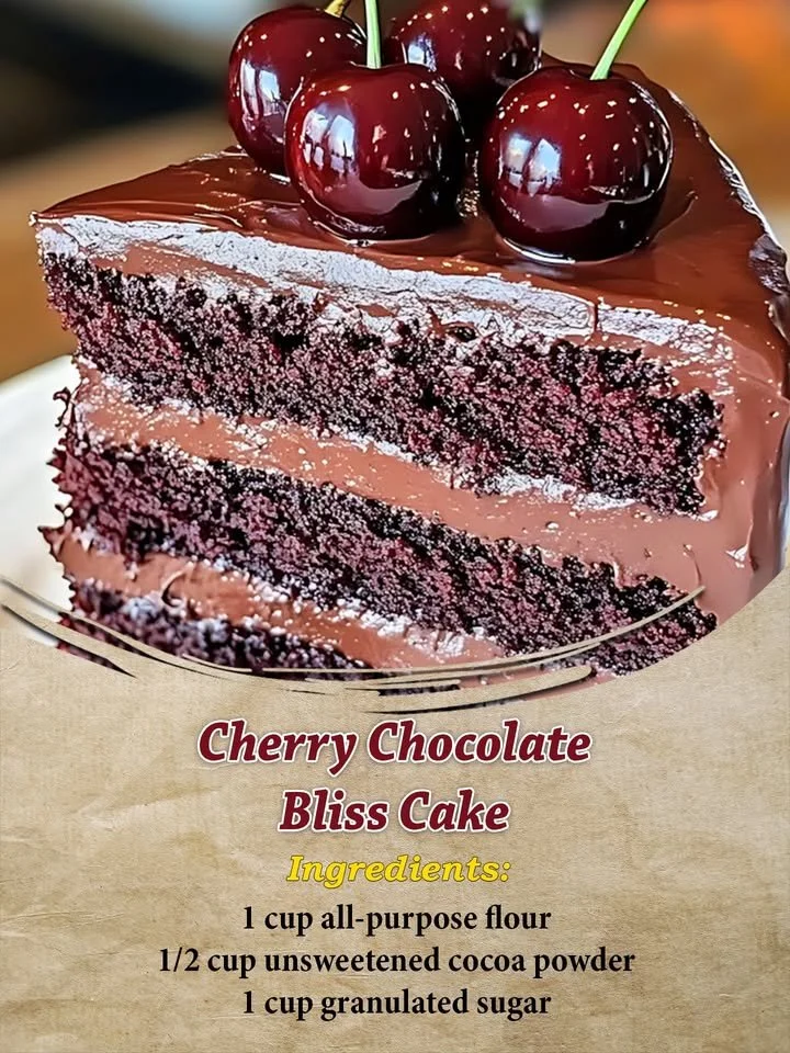 Slice of Cherry Chocolate Bliss Cake topped with cherries and chocolate ganache