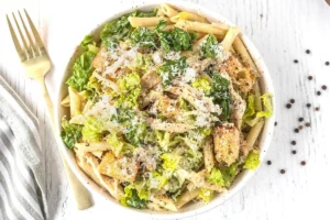 Chicken Caesar Pasta Salad with chicken, lettuce, and creamy dressing in a bowl.